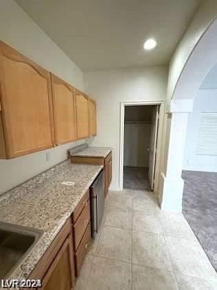 kitchen featuring light tile floors and light stone countertops