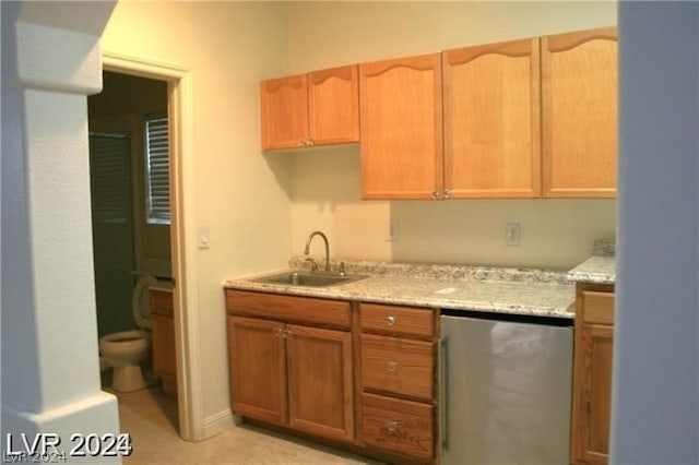 kitchen featuring dishwasher, sink, light tile flooring, and light stone counters