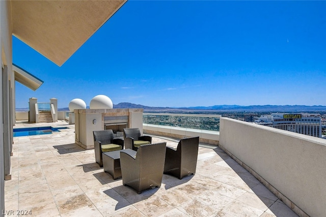 view of patio / terrace featuring area for grilling, a mountain view, and a balcony