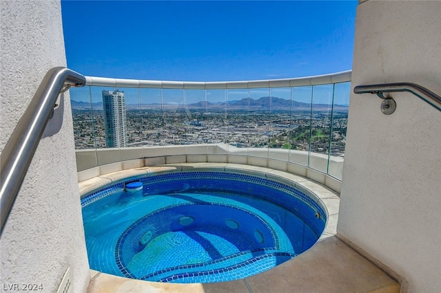 view of swimming pool featuring a mountain view and an in ground hot tub