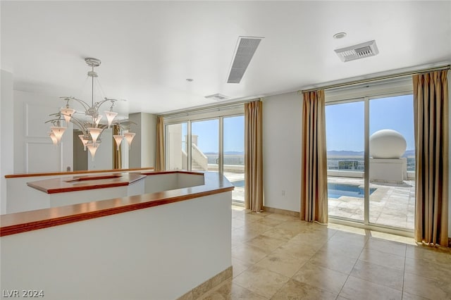 kitchen with pendant lighting, a notable chandelier, and light tile flooring