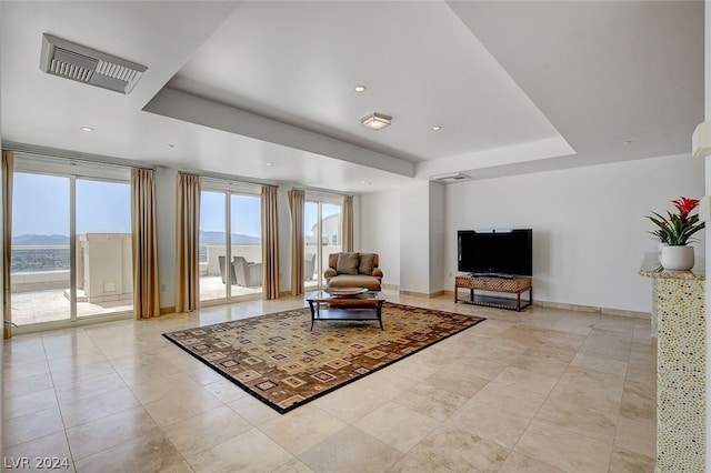 tiled living room featuring a tray ceiling