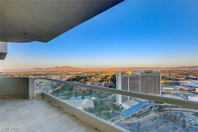 balcony at dusk featuring a mountain view