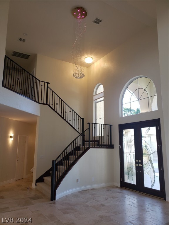 entrance foyer with french doors and a towering ceiling