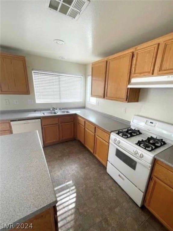 kitchen featuring sink, white appliances, and dark tile floors