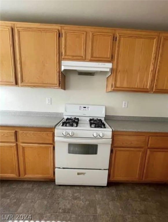 kitchen with dark tile floors and white range with gas cooktop