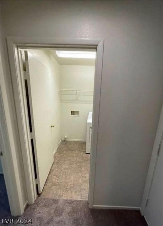 corridor featuring tile floors and washer / dryer