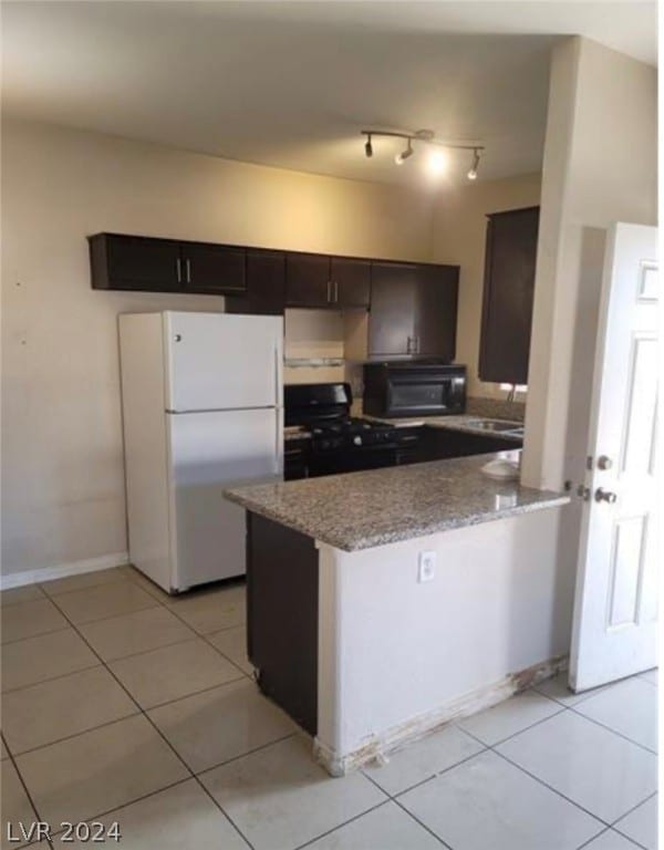 kitchen with white fridge, range, and light tile flooring