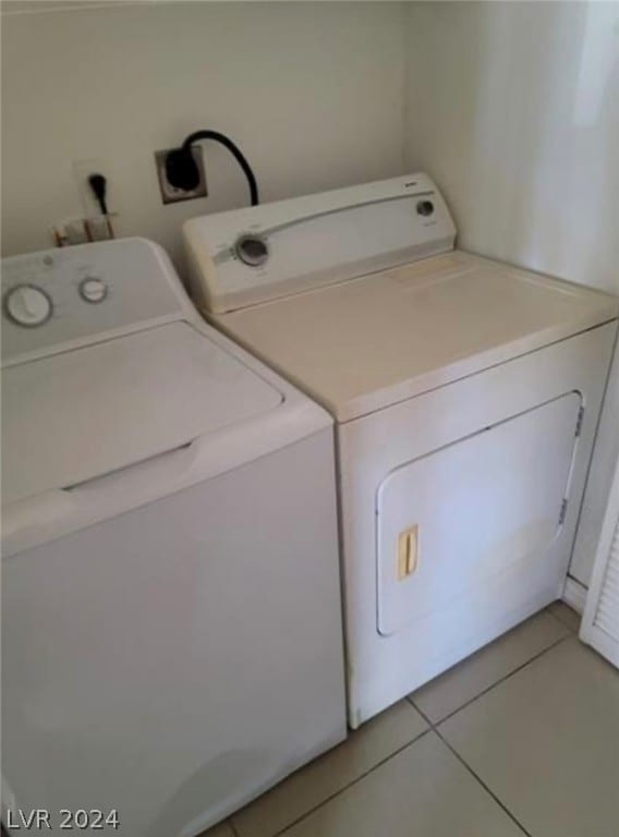 clothes washing area featuring independent washer and dryer, hookup for an electric dryer, and tile flooring