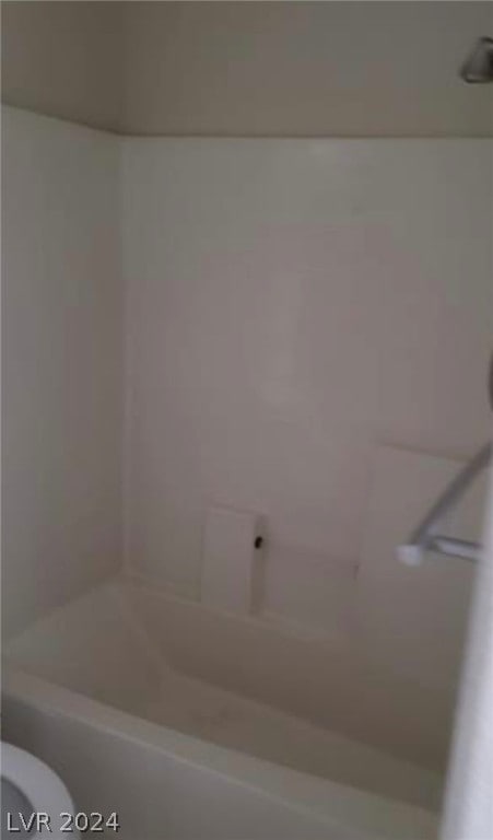 bathroom with tub / shower combination and toilet