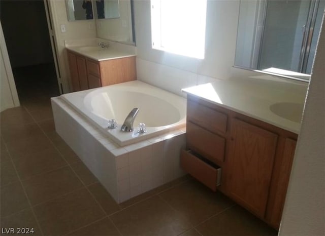 bathroom featuring a relaxing tiled bath, tile floors, and vanity