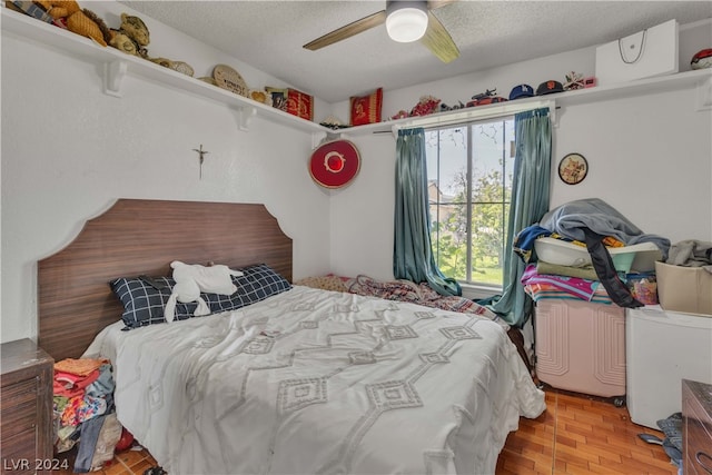 bedroom with ceiling fan, light hardwood / wood-style floors, and a textured ceiling