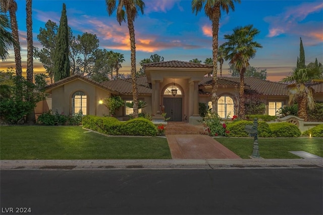 mediterranean / spanish house featuring a lawn