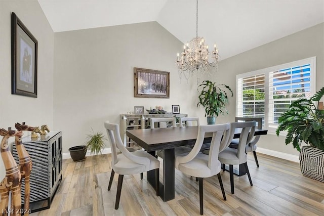 dining area with light hardwood / wood-style floors, lofted ceiling, and a notable chandelier