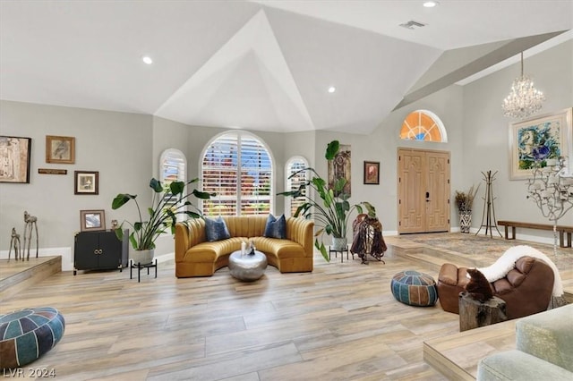 living room with light hardwood / wood-style floors, lofted ceiling, and a chandelier