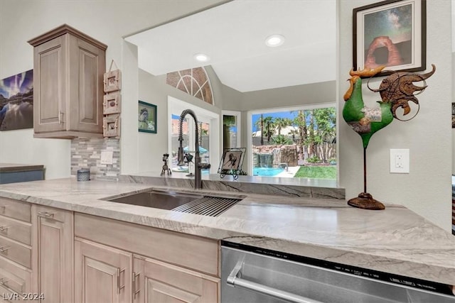 kitchen featuring dishwasher, lofted ceiling, light brown cabinets, decorative backsplash, and sink