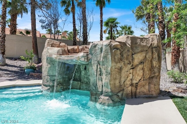 view of swimming pool with pool water feature