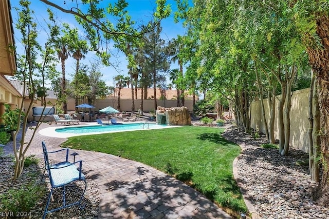 view of yard with pool water feature, a patio, and a fenced in pool