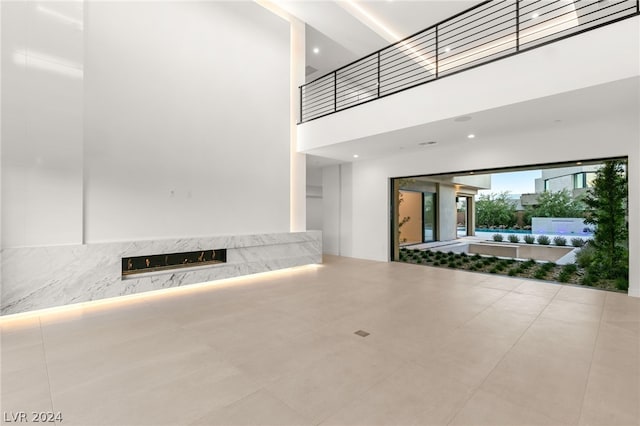 unfurnished living room featuring a towering ceiling