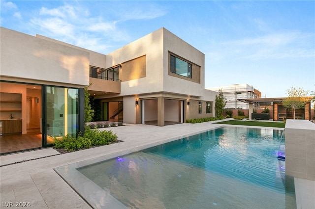 rear view of property with a balcony and a patio