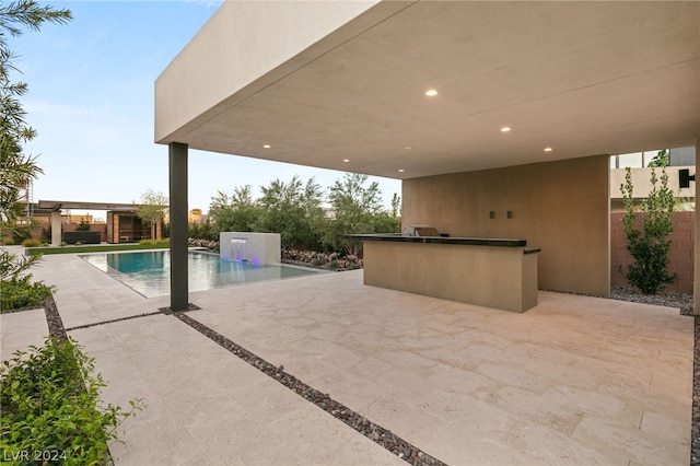 view of swimming pool featuring exterior kitchen, a patio area, and an outdoor bar