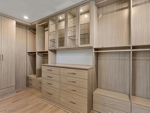 walk in closet with light hardwood / wood-style floors