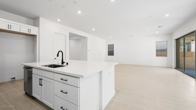 kitchen with sink, stainless steel dishwasher, an island with sink, white cabinets, and light tile patterned floors