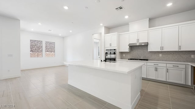 kitchen featuring white cabinetry, decorative backsplash, and a kitchen island