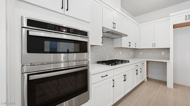 kitchen featuring appliances with stainless steel finishes, decorative backsplash, and white cabinets