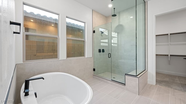 bathroom with separate shower and tub and tile patterned flooring