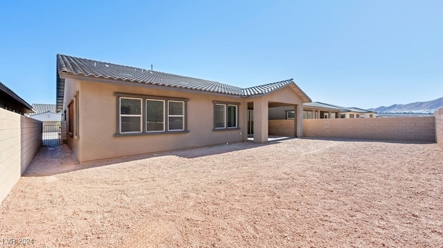 back of house featuring a mountain view and a patio