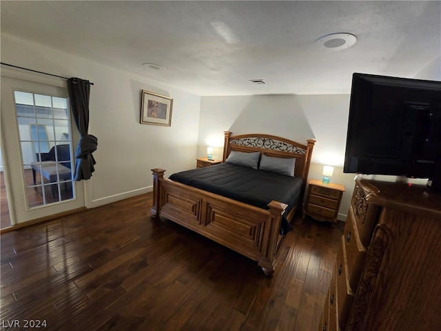 bedroom featuring dark hardwood / wood-style floors and a textured ceiling