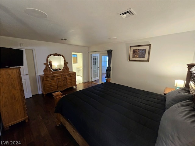 bedroom featuring ensuite bath and dark wood-type flooring