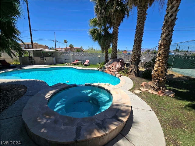 view of swimming pool featuring an in ground hot tub