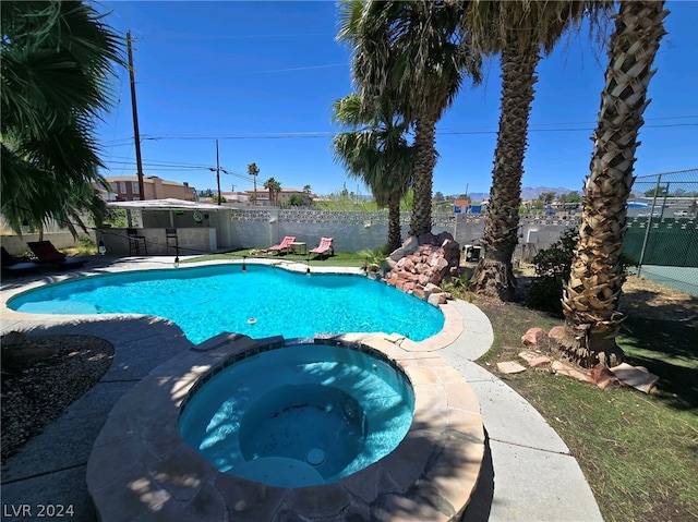 view of pool featuring an in ground hot tub