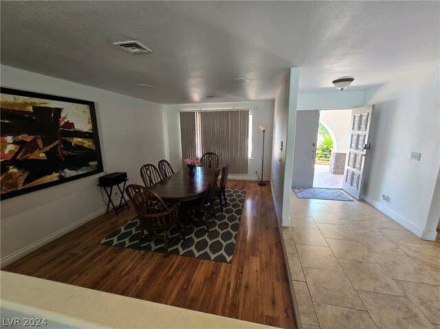 dining space with hardwood / wood-style floors and a textured ceiling