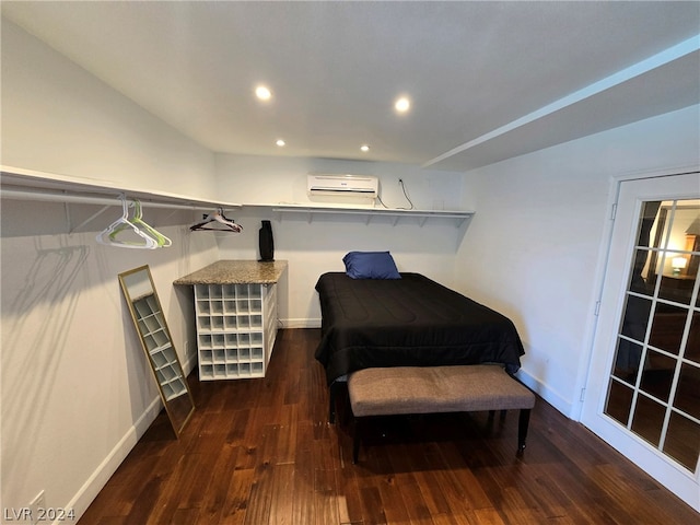 bedroom featuring a wall mounted air conditioner and dark hardwood / wood-style floors