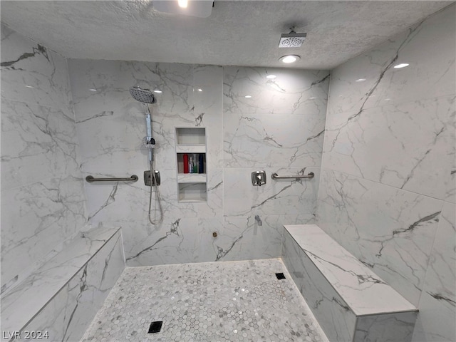 bathroom featuring a tile shower and a textured ceiling