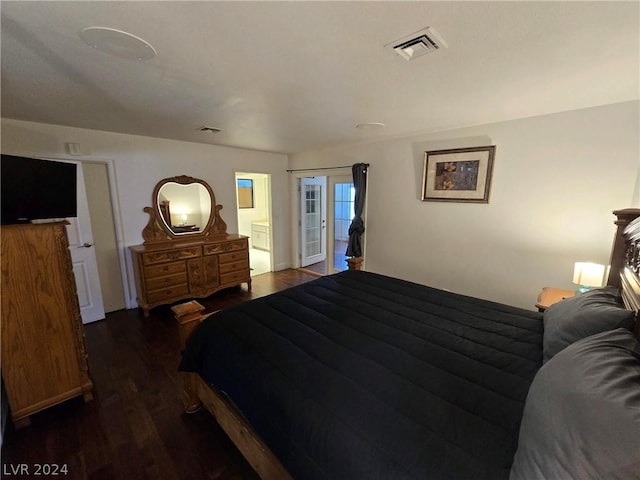 bedroom with dark wood-type flooring and connected bathroom