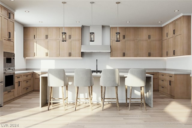 kitchen with decorative light fixtures, wall chimney range hood, light hardwood / wood-style floors, and a kitchen island