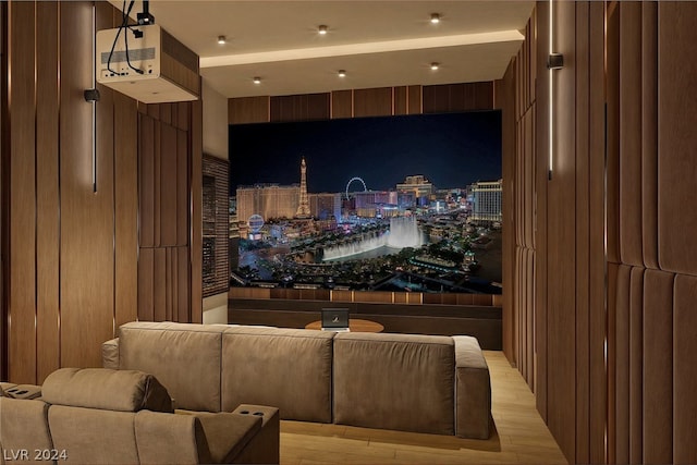 home theater room with wood walls and light hardwood / wood-style floors