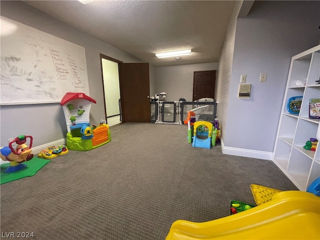 playroom featuring carpet flooring and a textured ceiling