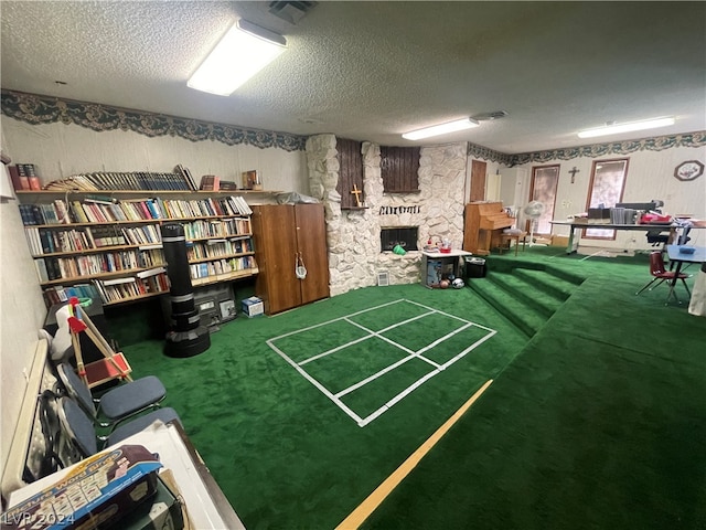 interior space featuring carpet flooring, a stone fireplace, and a textured ceiling