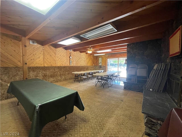 rec room featuring wood walls, billiards, ceiling fan, and a wood stove