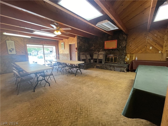 interior space with a fireplace, beam ceiling, ceiling fan, and carpet floors