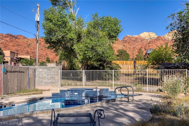 view of swimming pool with a mountain view and a patio area