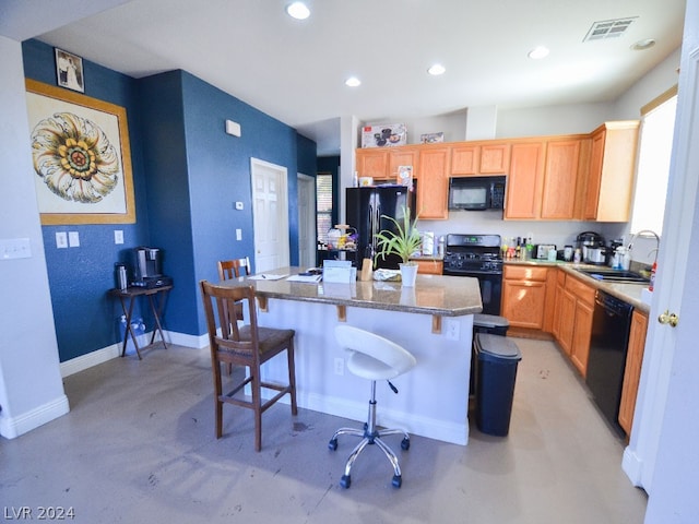 kitchen featuring a center island, light stone countertops, a kitchen breakfast bar, black appliances, and sink