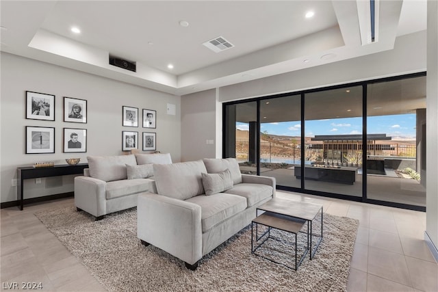 living room featuring light tile patterned floors and a tray ceiling