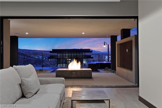 patio terrace at dusk with an outdoor living space with a fire pit