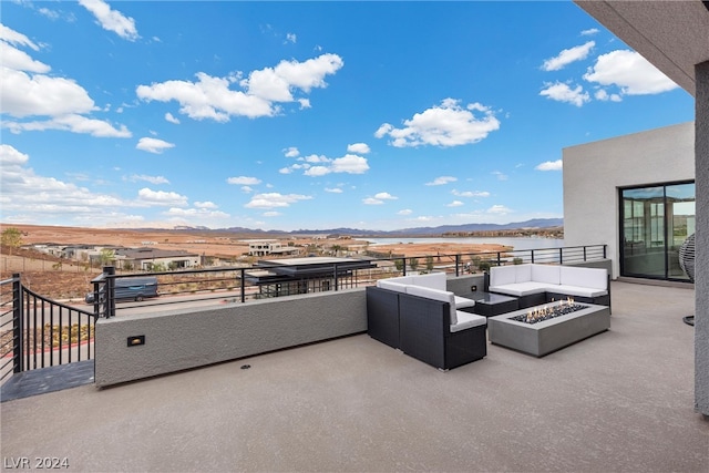 view of patio featuring a mountain view, a balcony, and an outdoor living space with a fire pit